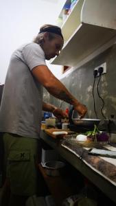 a man standing in a kitchen preparing food at Suna's Place in Ahangama
