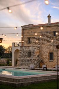 a building with a swimming pool in front of a building at Masseria Casina Fiocca in Pisignano