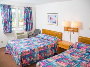 a hotel room with two beds and a table at Colonial motel in Wisconsin Dells