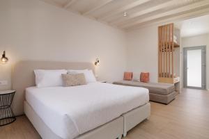 a white bedroom with a large bed and a chair at Dominoes Corfu in Ipsos +155 photos