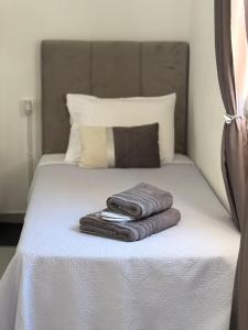 パトモスにあるDominik apartment 2のベッド1台(タオル2枚付)