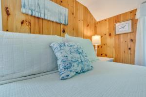 a bed with a blue and white pillow on it at Your Trail's End in Maine in Wayne