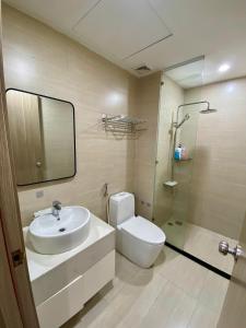 a bathroom with a sink and a toilet and a mirror at Hue Oi Homestay - Spacious 3-Bedroom Apartment with Balcony & Pool in Hue +4 photos