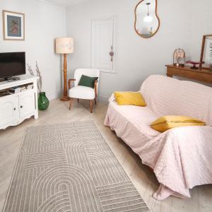 a bedroom with two beds and a tv and a chair at Jolie maison cosy in Saint-Uze