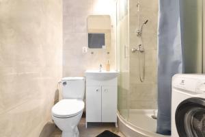 a bathroom with a toilet and a sink and a shower at Apartamenty Trójmiejskie - Sopot Forest 2 Bedroom in Sopot +6 photos