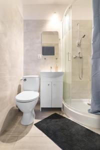 a bathroom with a toilet and a sink and a shower at Apartamenty Trójmiejskie - Sopot Forest 2 Bedroom in Sopot
