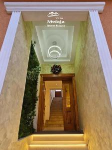eine Treppe in einem Gebäude mit einem Schild an der Decke in der Unterkunft Villa Mefaja in Kruja