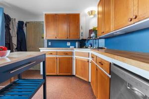 a kitchen with wooden cabinets and a blue wall at Highland Catttle Farm - Cozy Suite for Two - C in Loudon