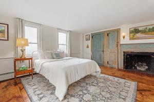 a white bedroom with a bed and a fireplace at Highland Catttle Farm - Cozy Suite for Two - C in Loudon