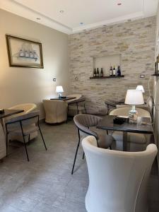 a restaurant with tables and chairs and a brick wall at Camere del Corso in Tempio Pausania