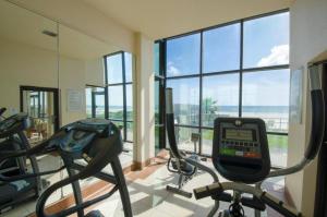a gym with two elliptical machines and a large window at Oceanview 2 Studios adjoining w/pool, kitchenettes in Daytona Beach