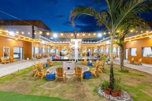 Resort Mini Mới Khai Trương في فنغ تاو: فناء خارجي به طاولات وكراسي و نخلة
