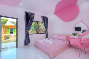 Resort Mini Mới Khai Trương في فنغ تاو: غرفة نوم وردية مع سرير وردي ومرآة +80 صورة