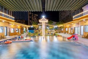 Resort Mini Mới Khai Trương في فنغ تاو: حمام سباحة داخلي مع حديقة مائية في الليل