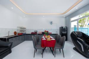 Resort Mini Mới Khai Trương في فنغ تاو: غرفة طعام مع طاولة حمراء وكراسي