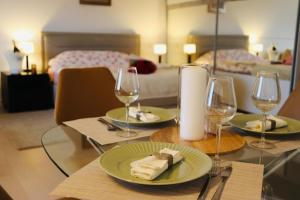 a table with two plates of food and wine glasses at Vernescu 4 Luxury Living - Terrace Central Chic in Bucharest