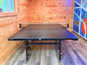 a ping pong table in a room with wooden walls at Full Hookup 30 Amp pull through up to 33Ft Site ONLY in Gaines