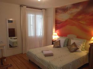a bedroom with a bed with a painting on the wall at Villa Do Sol Chambre d'Hôtes "La Dune" in Arcachon