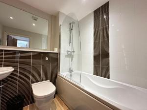 un bagno con vasca, WC e lavandino di Seaside APT with Harbour View a Swansea Altre 21 foto