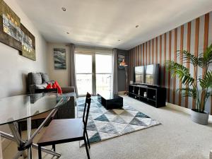 un soggiorno con tavolo in vetro e TV di Seaside APT with Harbour View a Swansea