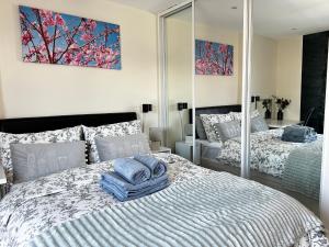 una camera con due letti e asciugamani sopra di Seaside APT with Harbour View a Swansea