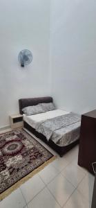 a bedroom with a bed and a rug at KOTA TINGGI homestay in Kota Tinggi