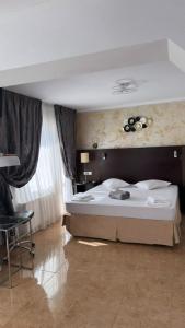 a bedroom with a large bed and a chair at Pensiunea Diamond in Eforie Nord +11 photos