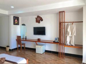 a living room with a television and a dressing table at Thmor Da Guest House in Kampong Cham