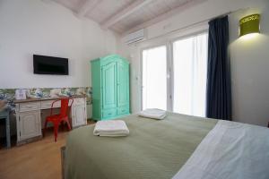 切萨雷奥港L'Ulivo e la Stella的卧室里有一张床，床边有一个绿色的柜子，还有一张书桌 更多47张照片