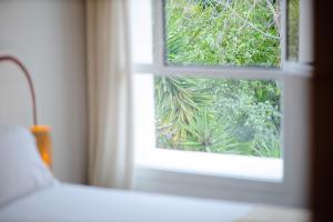 a window in a room with a view of a plant at Hôtel Le Sud in Juan-les-Pins