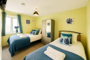 zwei Betten in einem Zimmer mit gelben Wänden in der Unterkunft Maidstone House Kent By Smart Corporate Stays in Maidstone