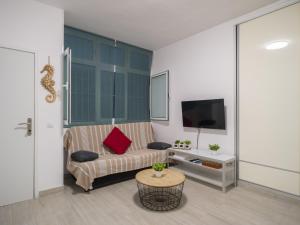 Una sala de estar con un sofá y un televisor. en Canteras Canary Beach, en Las Palmas de Gran Canaria