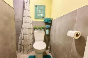 ein Badezimmer mit einer Toilette und einem Schild mit der Aufschrift „Lasst uns zu Hause bleiben“ in der Unterkunft Maidstone House Kent By Smart Corporate Stays in Maidstone