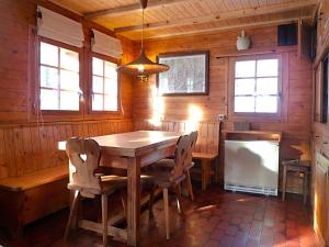 a dining room with a wooden table and chairs at Chalet Le Recoulet 4 personnes - Evolene in Evolène +5 photos