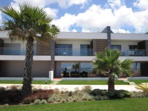 ein Gebäude mit Palmen davor in der Unterkunft Poolvilla Mario Ocean View in Atalaia