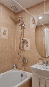 un bagno con doccia, vasca e lavandino di Saulės laikrodžio apartamentai a Šiauliai