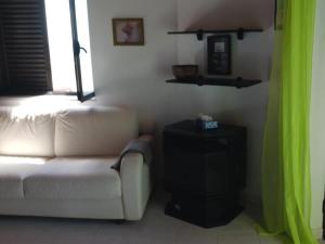 a living room with a white couch and a green curtain at Casa da Torre Rooftop Terrace in Praia da Areia Branca