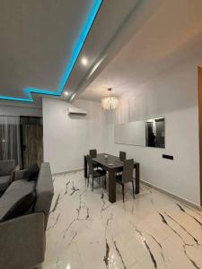 a dining room with a table and a couch at Appartement moderne in Marrakech +2 photos