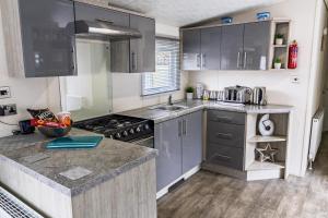a kitchen with gray cabinets and a counter top at 13 The Avenue in Tattershall