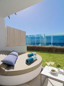 a patio with two blue pillows and a table at Don Gregory by Dunas - Adults Only in San Agustin