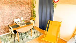 a room with a table and chairs and a brick wall at Appartement agreable et zen in Boulogne-sur-Mer