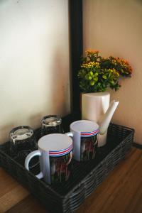 a tray with three coffee cups and a vase with flowers at Bamboo River Lodge in Horquetas +54 photos