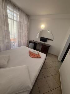 a bedroom with a white bed and a mirror at Vila njoy by the sea in Eforie Sud