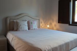 a bedroom with a white bed with pillows and a window at Herdade Paraíso da Moçarria in Santarém +45 photos