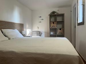 Un dormitorio con una cama grande y una silla. en Casa Margherita Castiglioncello, en Castiglioncello