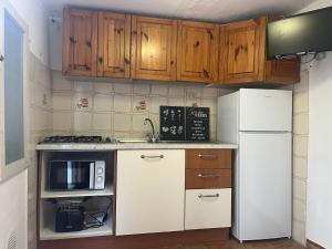 Una cocina con electrodomésticos blancos y gabinetes de madera. en Casa Margherita Castiglioncello, en Castiglioncello 16 fotos más