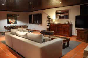 a living room with a white couch and a tv at Herdade Paraíso da Moçarria in Santarém