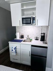 デイトナビーチにあるNew updated Daytona Oceanview w/kitchenette, poolのシンクと電子レンジ付きの小さなキッチン