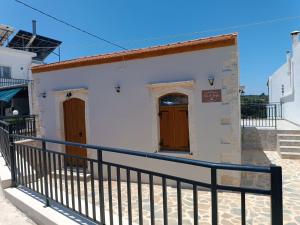 a white building with brown doors on it at Terra di Karfis in Margarítai