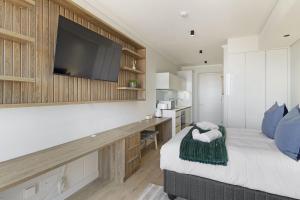 a bedroom with a bed with a tv on the wall at Ellipse Waterfall 3802 in Midrand
